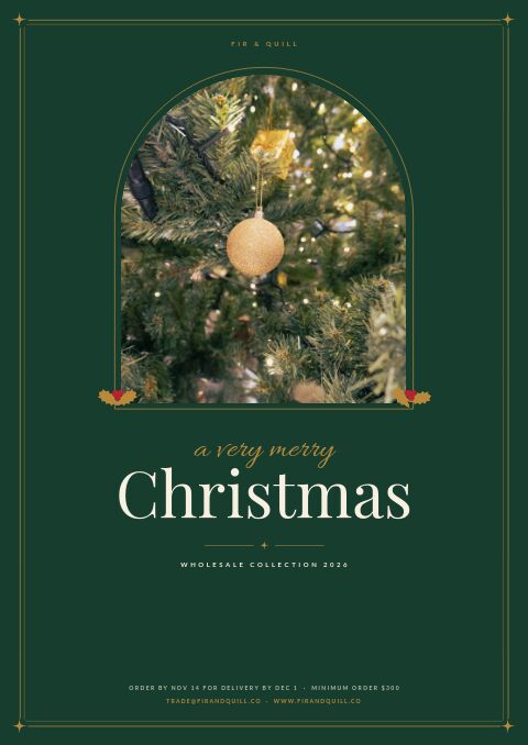Christmas catalog cover in forest green with an arched photo of a decorated tree and a gold bauble in a gold frame